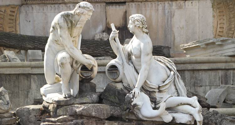 Statues classiques dans une fontaine historique.