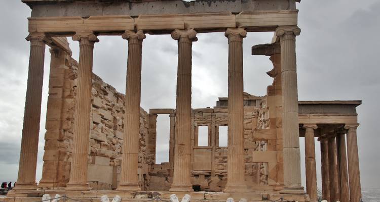Ancient Greek temple ruin with columns and stone walls.