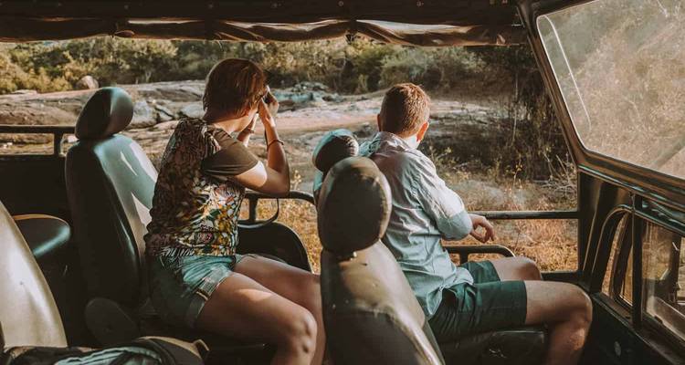 Twee mensen in een safarivoertuig op een wildlife-avontuur.