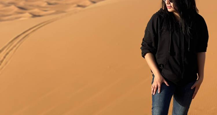 Person standing on a sand dune in the desert.