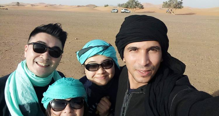Group of four friends posing for a selfie in the desert.