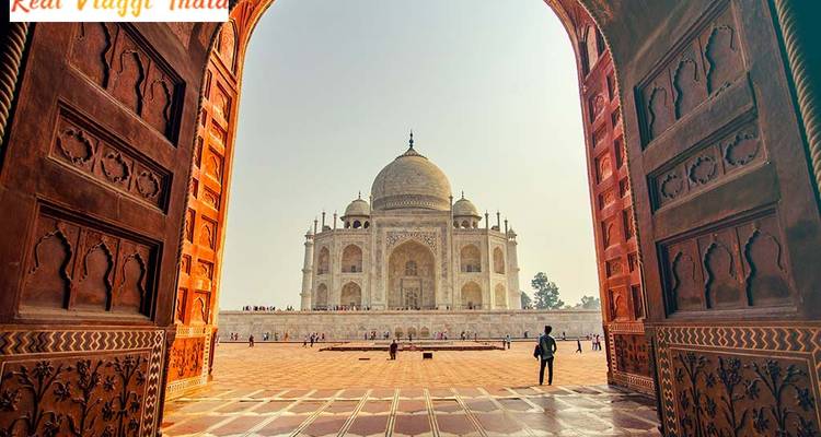 Iconic Taj Mahal viewed through an arched entrance.