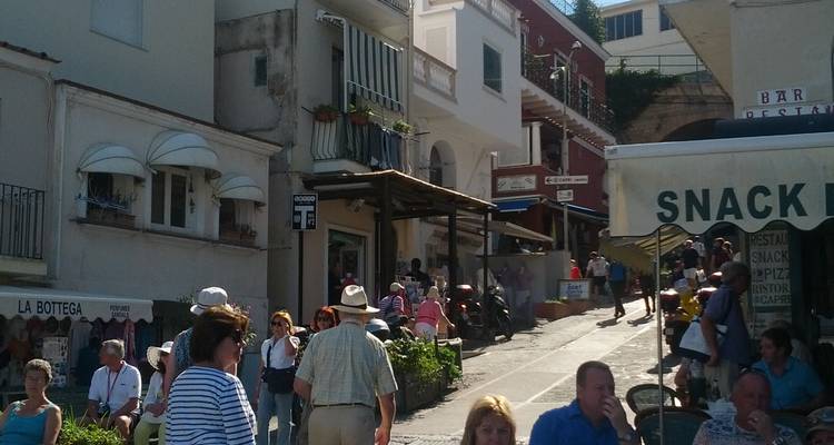 Busy street in a European town with people and shops.