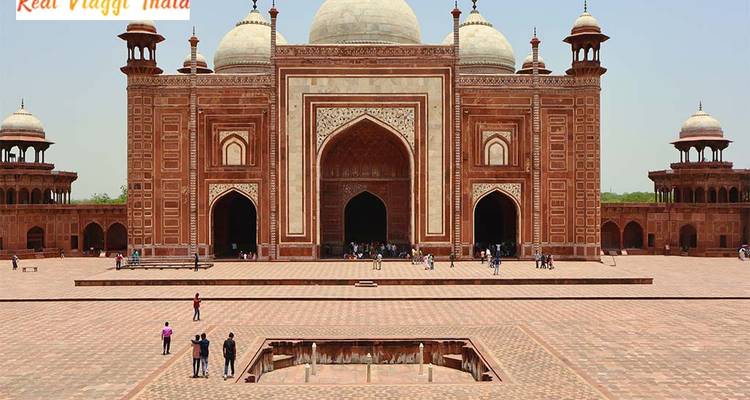 Una gran mezquita con minaretes y gente en el patio.