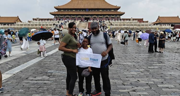 Three people posing at the entrance of the Forbidden City.