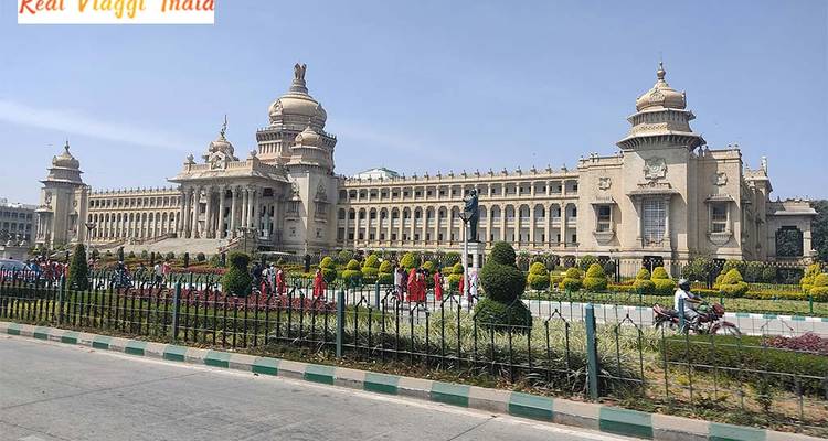 Vidhana Soudha, ein großes Regierungsgebäude in Bangalore mit Textüberlagerung.