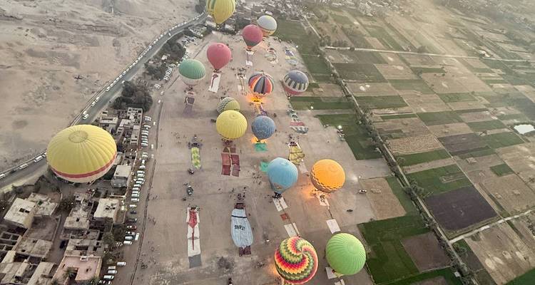 De nombreuses montgolfières au-dessus de champs agricoles vues d'en haut.