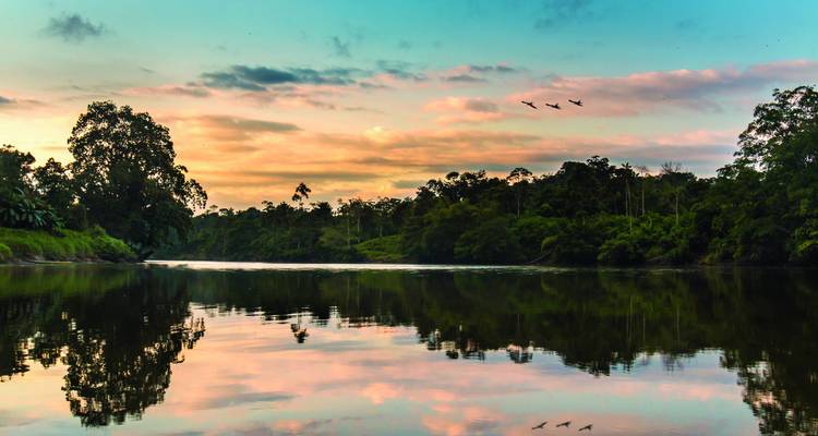 Ruhiger Sonnenuntergang über einem Fluss mit Spiegelungen.