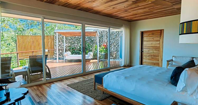 Modernes Hotelzimmer mit großen Fenstern und einem Außenbereich.