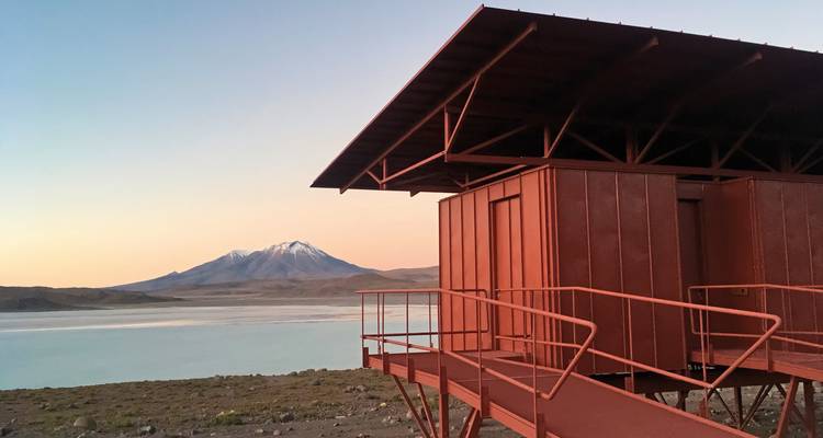 Rotes Gebäude mit einem Vulkan im Hintergrund in der Abenddämmerung.