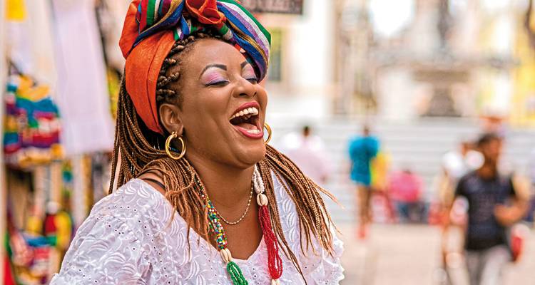 A joyful person wearing traditional Brazilian clothing and accessories.