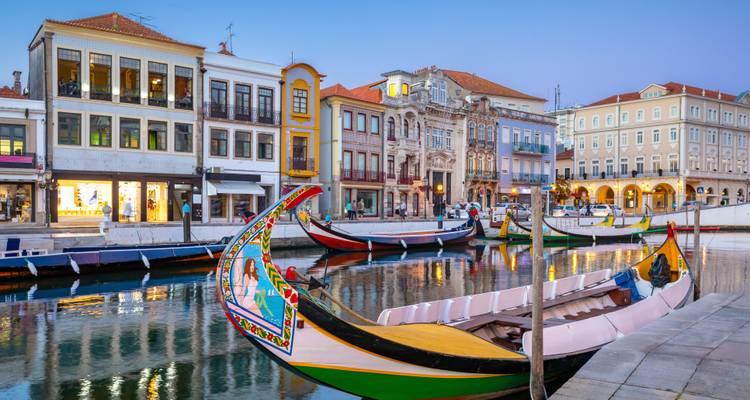 Canal avec des bateaux colorés et des bâtiments historiques à Aveiro.