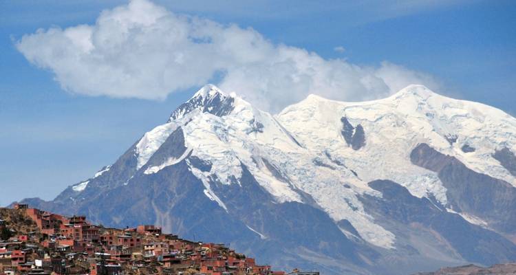 Montagnes enneigées avec des bâtiments éparpillés à la base.