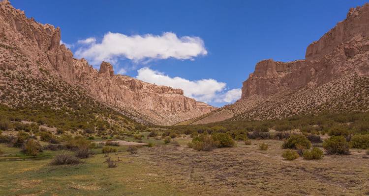Paysage de vallée accidenté avec un ciel bleu clair.