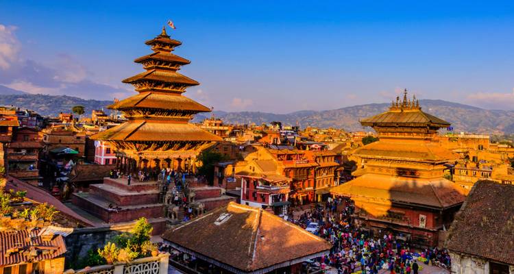 Belebter Platz mit historischen Tempeln und Menschen.