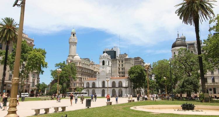 Place ensoleillée avec le bâtiment colonial blanc du Cabildo, sa tour de l'horloge et l'architecture historique environnante.