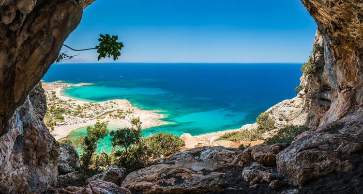 Cave view overlooking a coastline with turquoise waters.