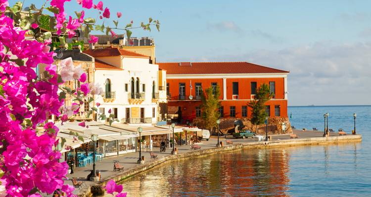 Harbor in a Greek town surrounded by colorful buildings.