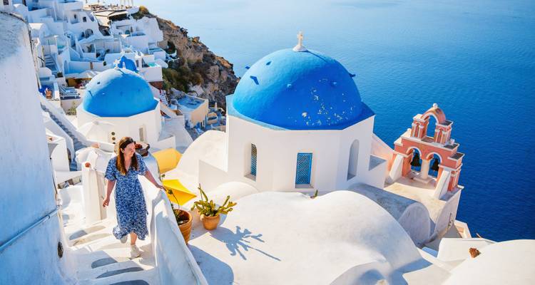 Person viewing the blue domes of Santorini.