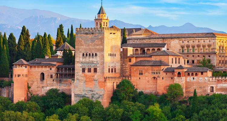 An ancient palace surrounded by lush greenery and mountains.
