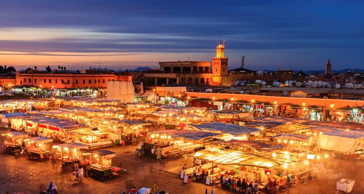 Nighttime view of a vibrant market with illuminated stalls.