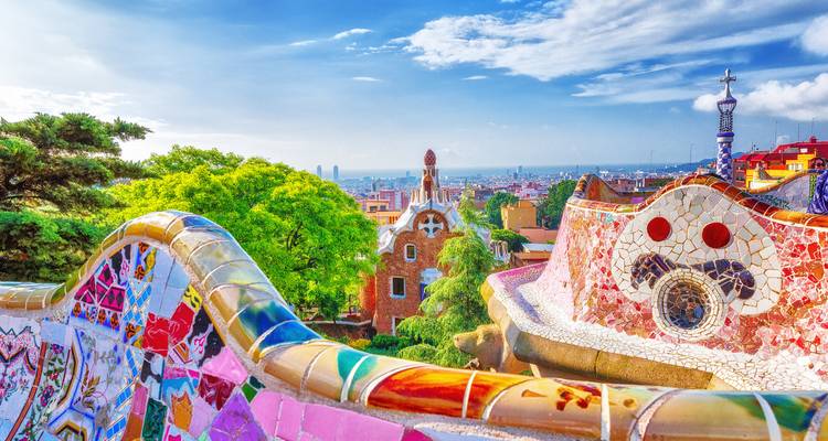 Vibrant mosaic artwork in a park setting with city views.