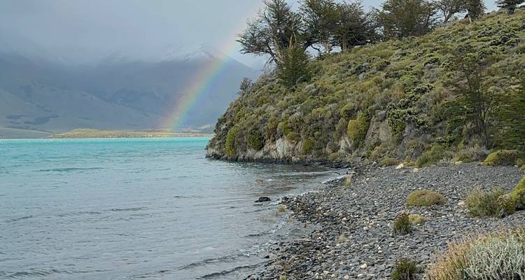 Vista al lago con un arcoíris en las montañas.
