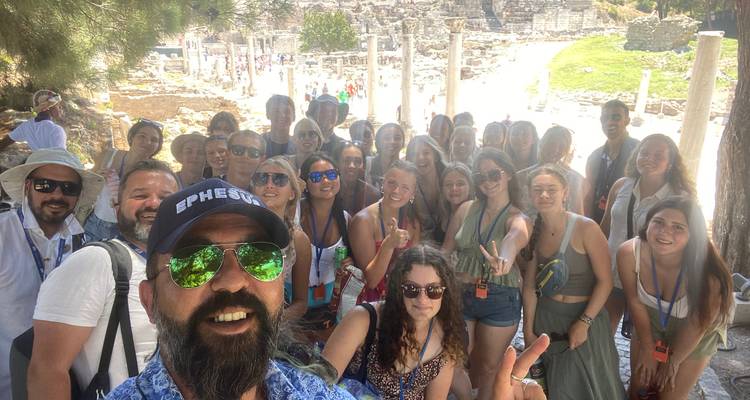 Grote groepsselfie met oude ruïnes op de achtergrond