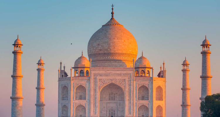 Taj Mahal au coucher du soleil se reflétant sur l'eau.