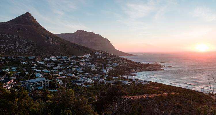Vista costera con montañas y atardecer.