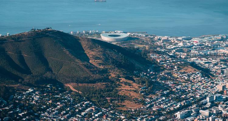 Vista aérea de una ciudad con un estadio junto al mar.