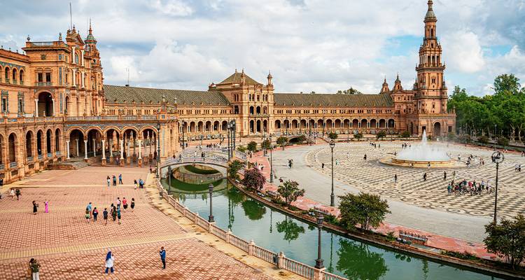 La grandiose Plaza de España de forme semi-circulaire à Séville est dotée de ponts ornés, d'une fontaine centrale et d'un canal de réflexion.