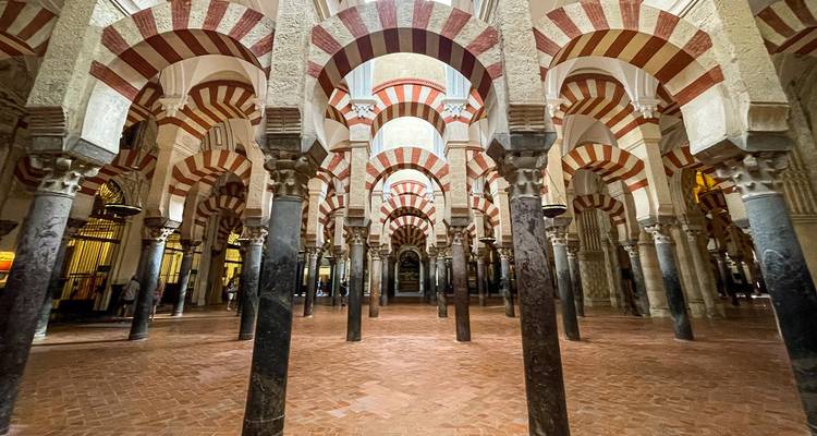 Des rangées d'arcs rayés et de colonnes en marbre créent une perspective infinie à l'intérieur de la Mosquée de Córdoba.