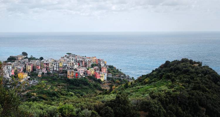 Vue panoramique d'un village coloré surplombant la mer.