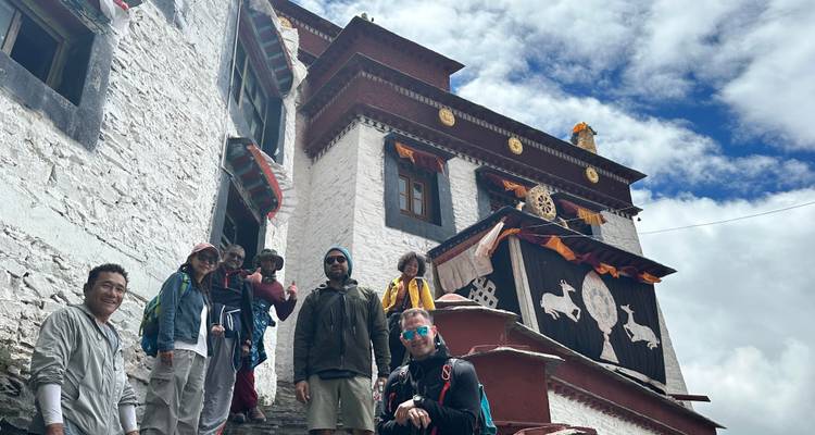 Groupe de personnes visitant un bâtiment traditionnel à l'architecture ornée.
