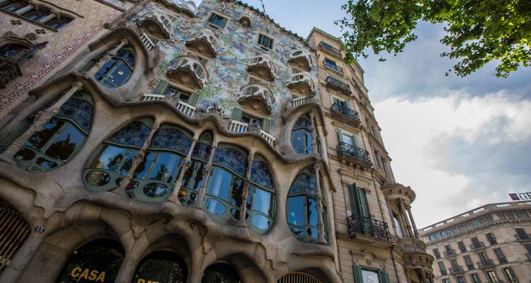 Verzierte Fassade des Casa Batlló in Barcelona mit wellenförmigen Balkonen und farbenfrohen Mosaiken.