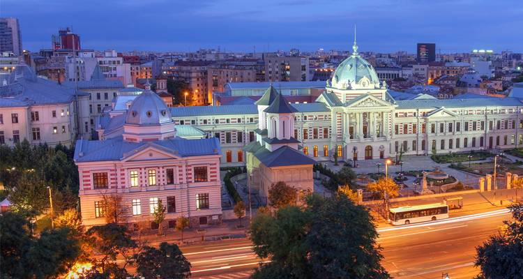 Edificios históricos iluminados y senderos de luz activos a la hora azul en el centro de Bucarest
