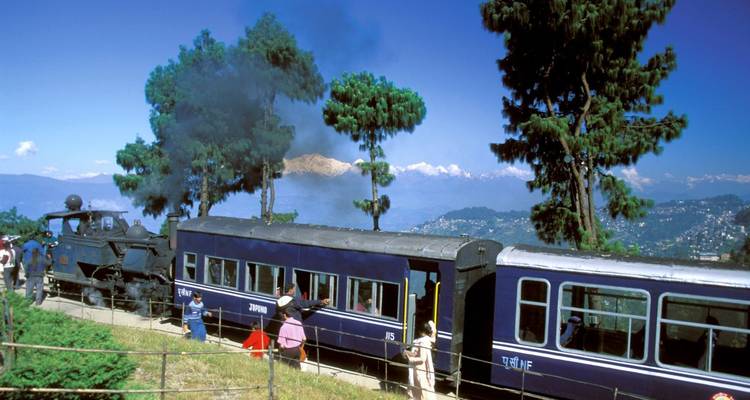 Historische Dampflokomotive durchquert eine hügelige Landschaft.