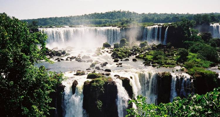 Varias cascadas que caen en cascada hacia un área boscosa.