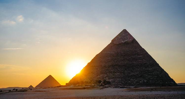 Pyramids with the sun setting behind them.