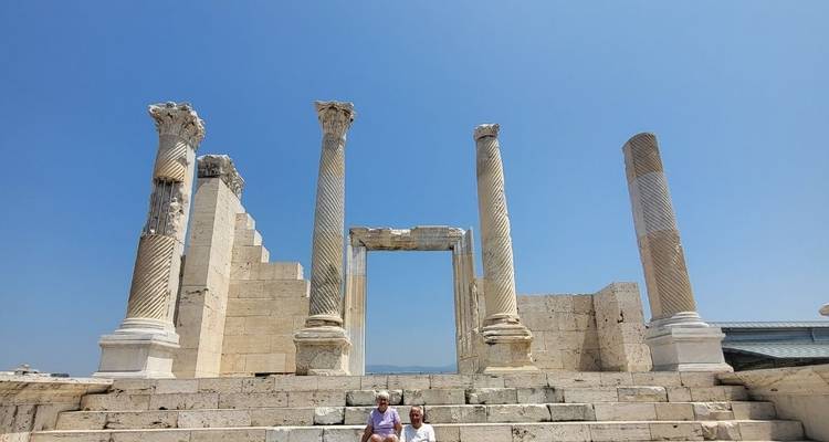 Personas posando frente a columnas antiguas y ruinas.