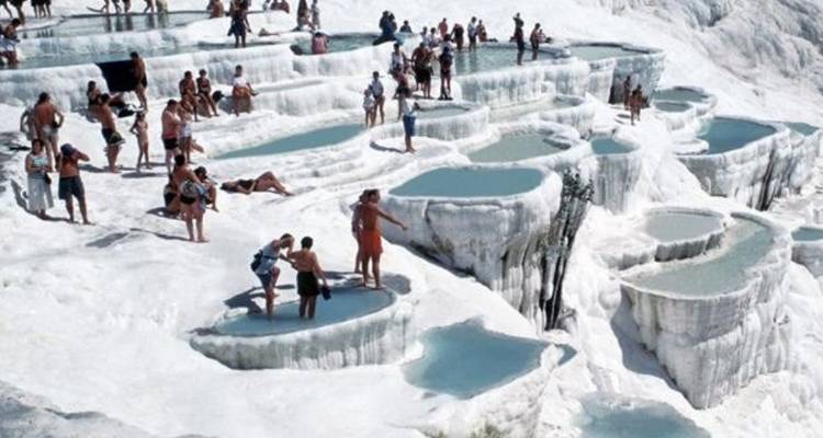 Personas disfrutando de las piscinas termales y terrazas en Pamukkale.