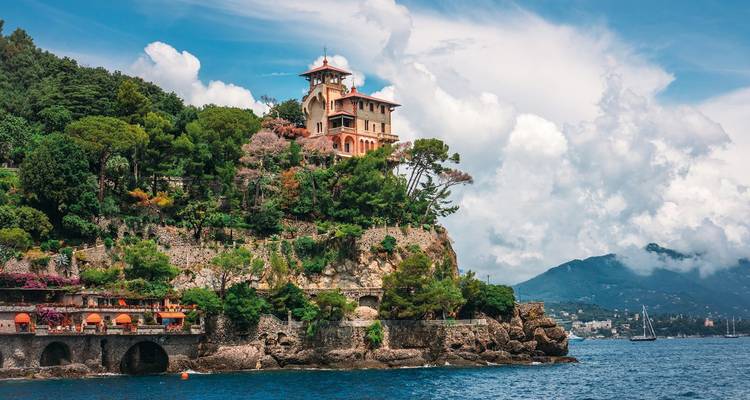 Scenic coastal view with a villa perched on a cliff.