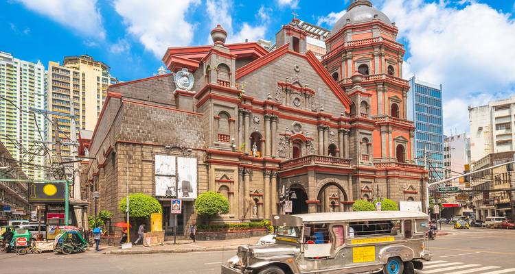 Historische Binondo-Kirche in Manila mit einem farbenfrohen Jeepney, der vorbeifährt