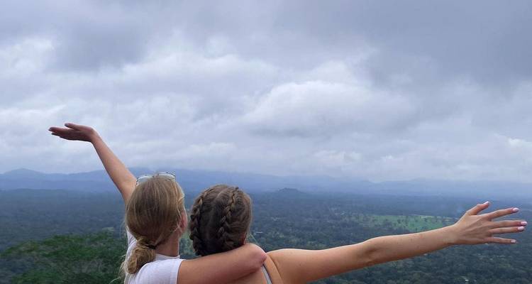 Two women embracing and looking out over a vast landscape.