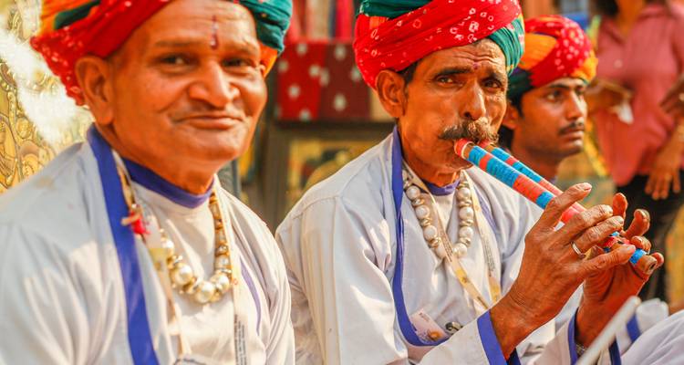 Musicians at a cultural event in traditional attire.