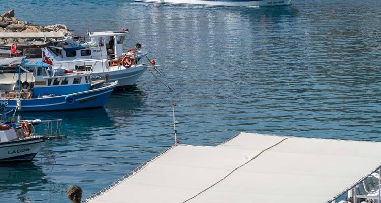 Primer plano de barcos atracados en una superficie de agua en calma.