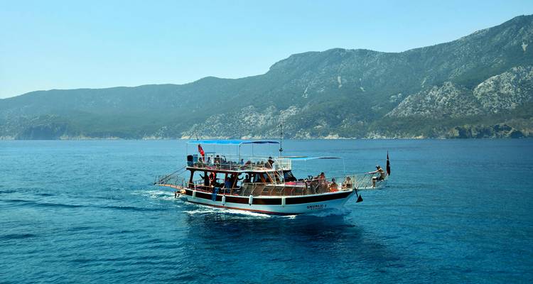 Un barco con turistas en un mar pintoresco.