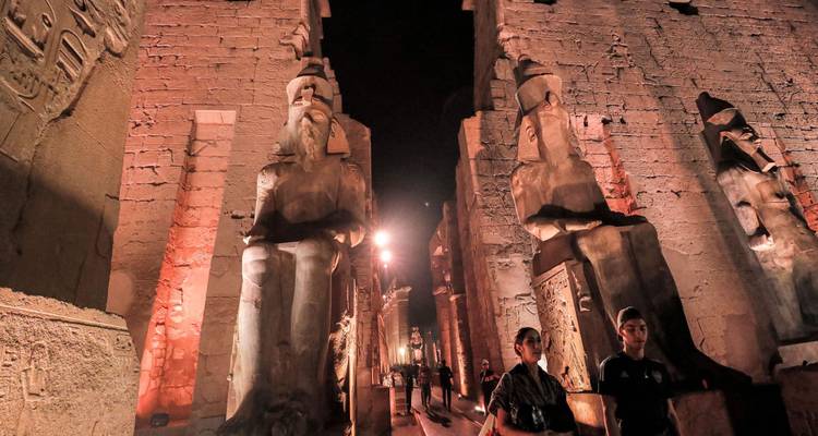 Ancient statues in a temple at night.