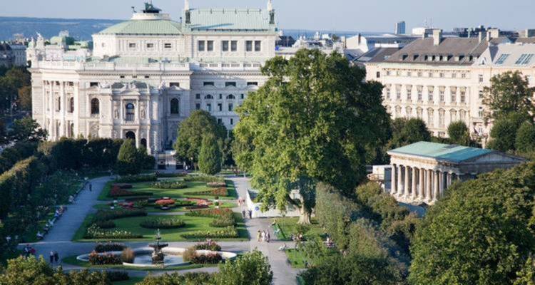 Vue sur le parc avec arbres et bâtiments environnants.